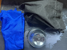 Blue and black gloves on a map with a metallic object