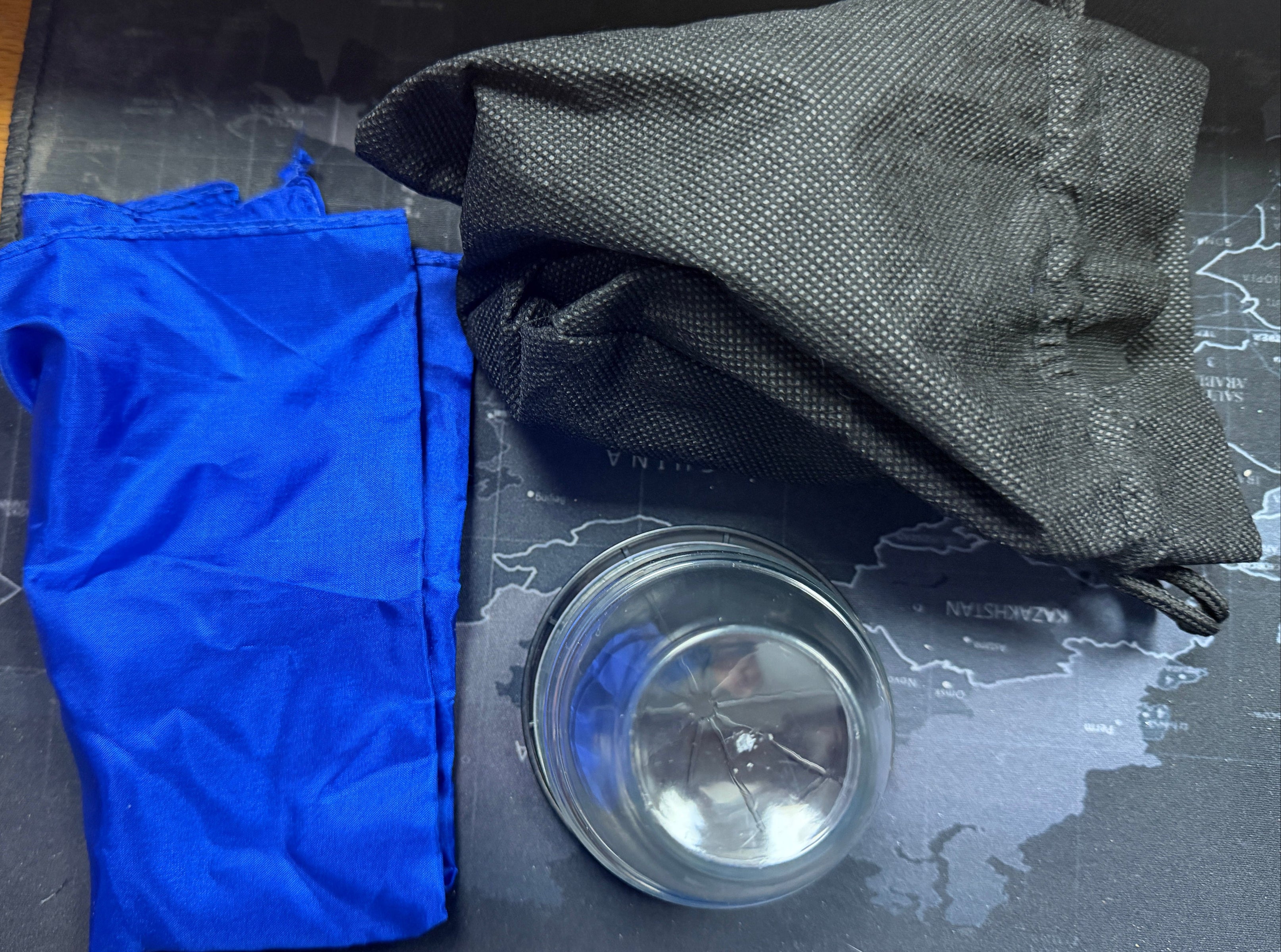 Blue and black gloves on a map with a metallic object