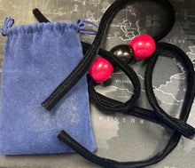 Black hair ties with pink beads on a map background