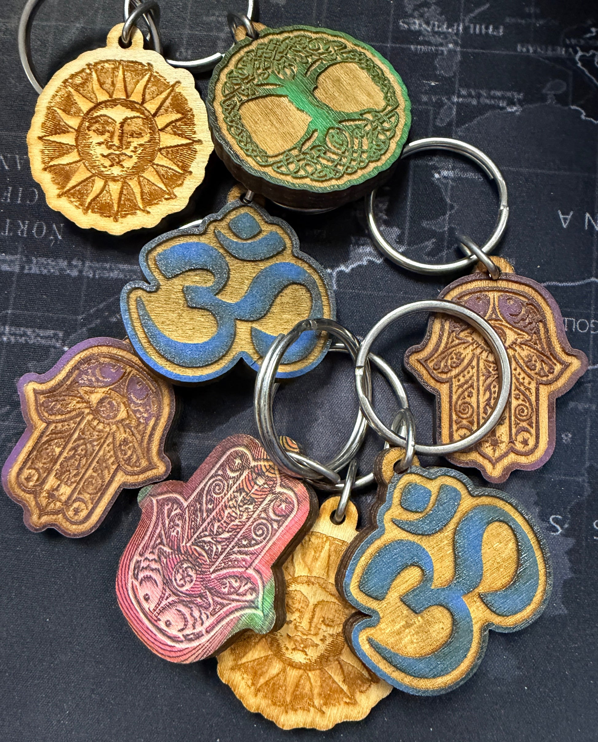Collection of decorative keychains with intricate designs on a textured surface.