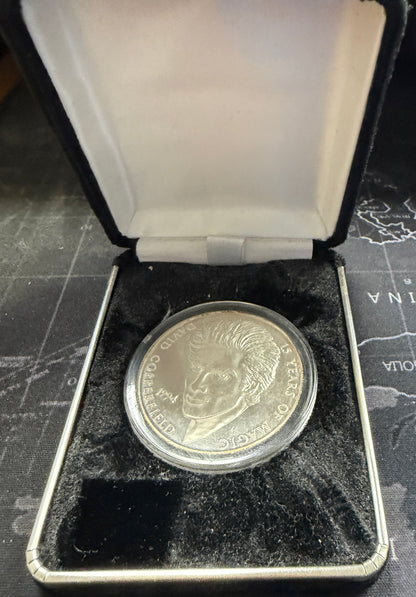 Silver coin in a display case on a map background