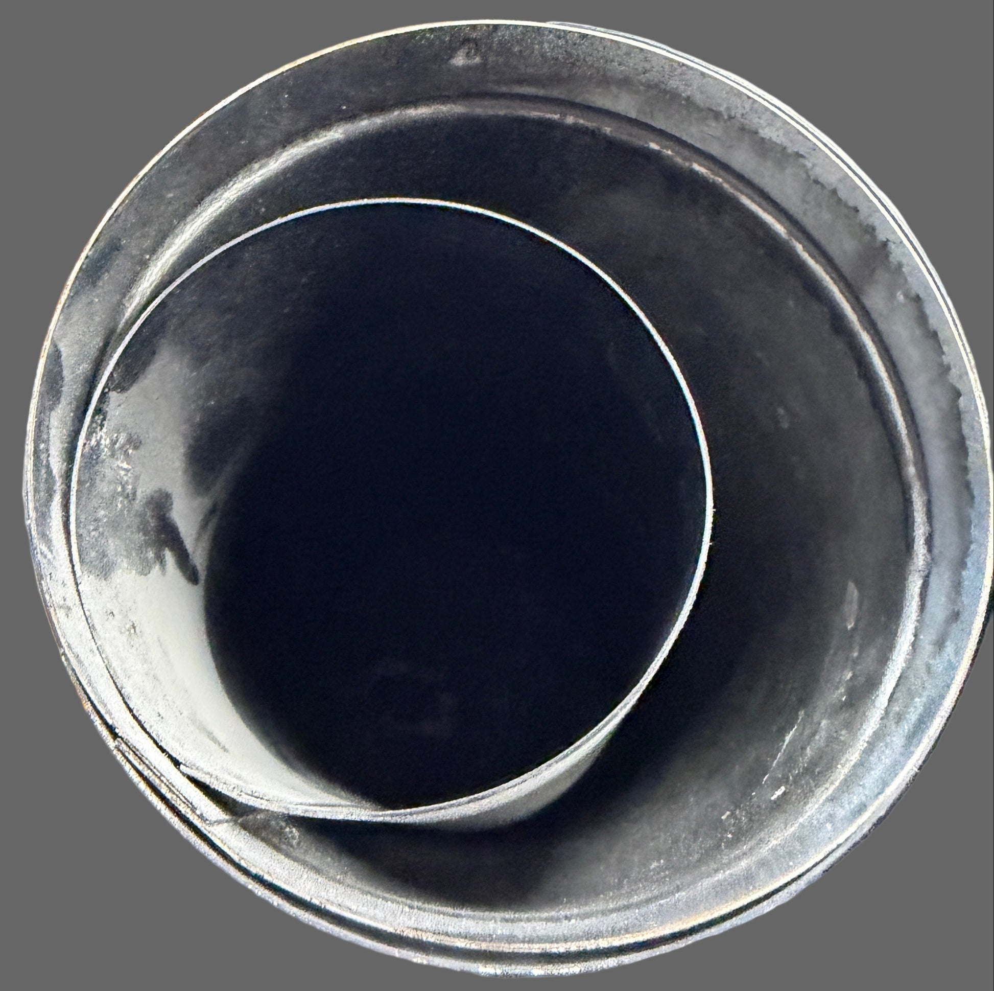 Black cup on a cluttered desk with various items in the background