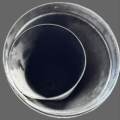 Black cup on a cluttered desk with various items in the background