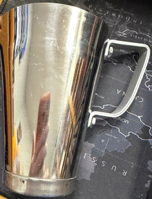 Metallic cylindrical object with a handle on a textured surface