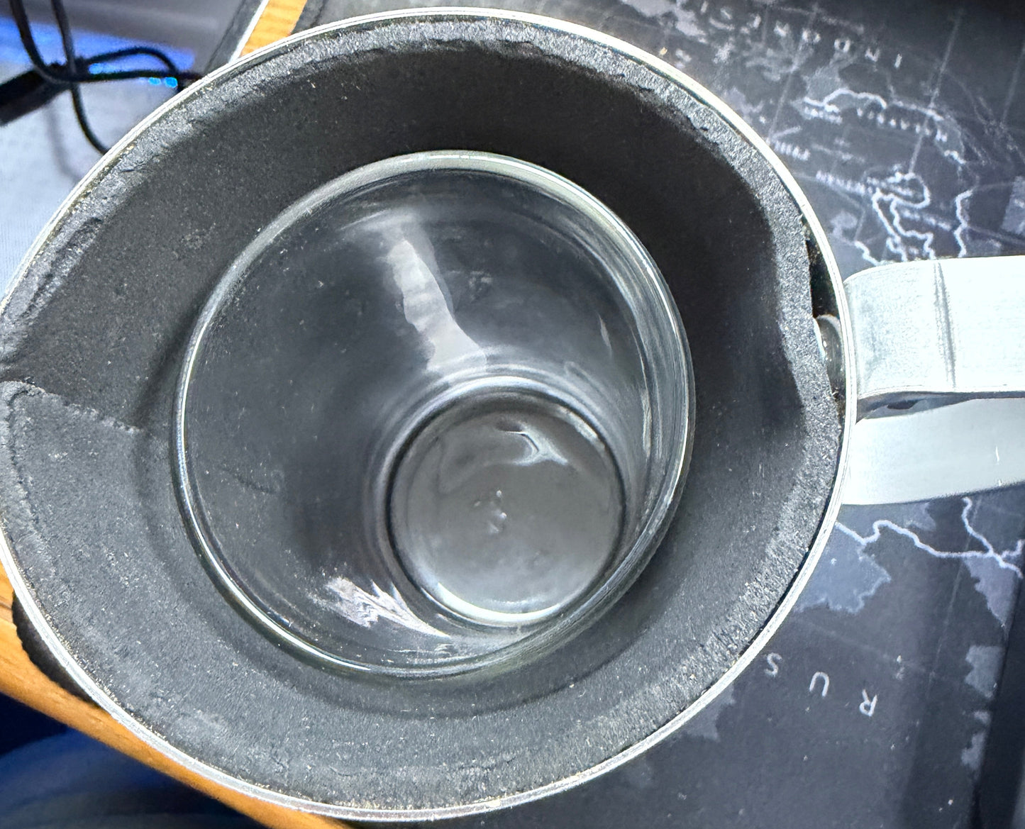 Metallic container with a glass-like interior on a dark surface