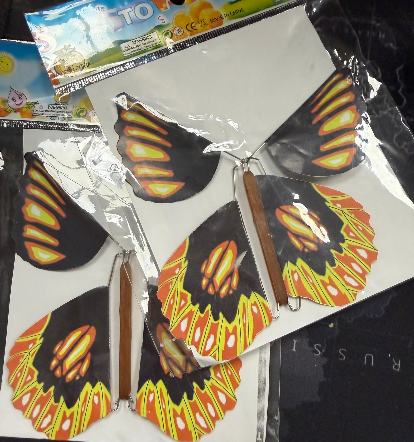 Butterfly wing decorations in packaging on a dark surface