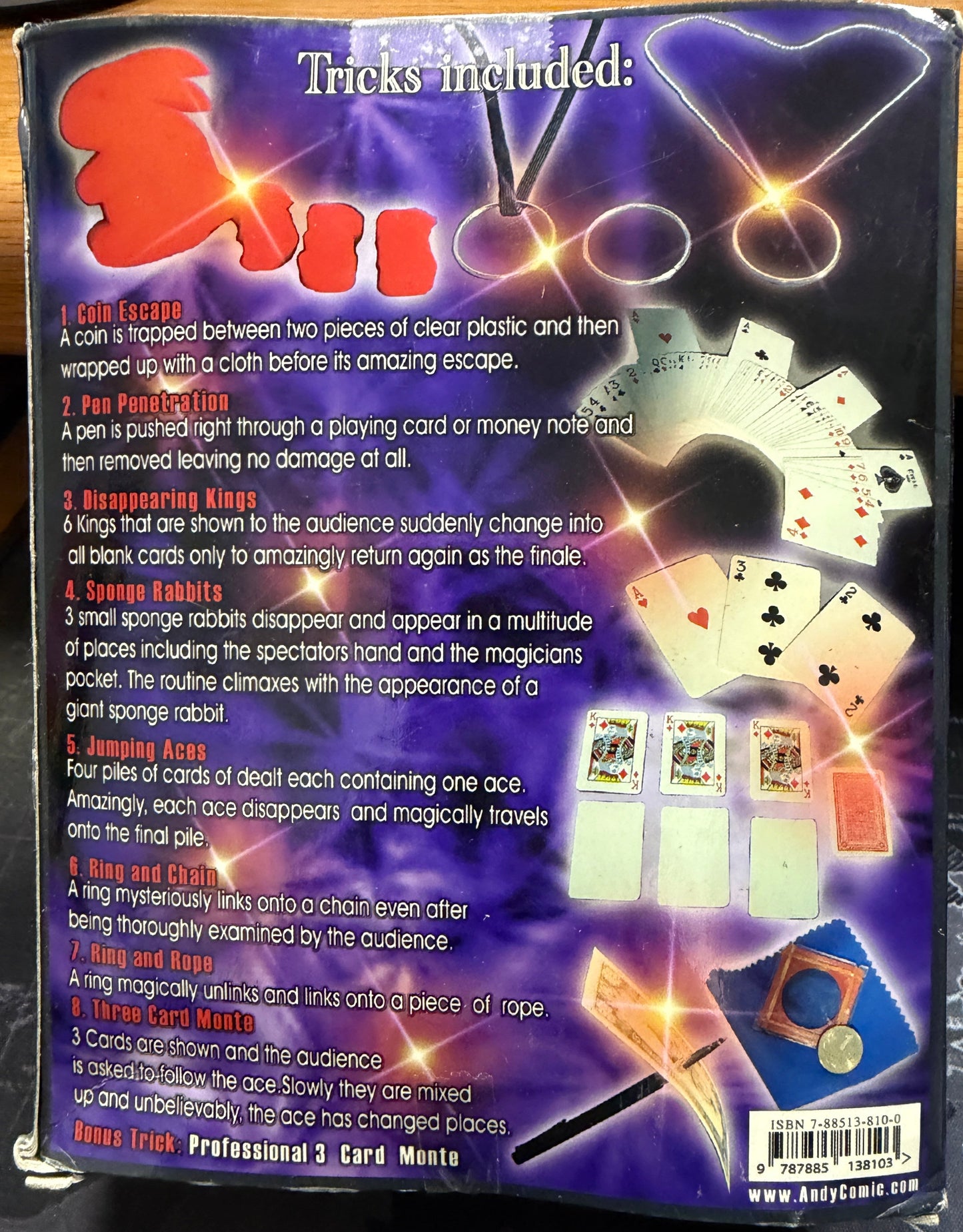 Cardboard box with playing cards and magic tricks included on a dark background