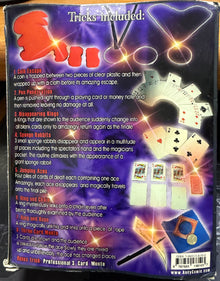 Cardboard box with playing cards and magic tricks included on a dark background