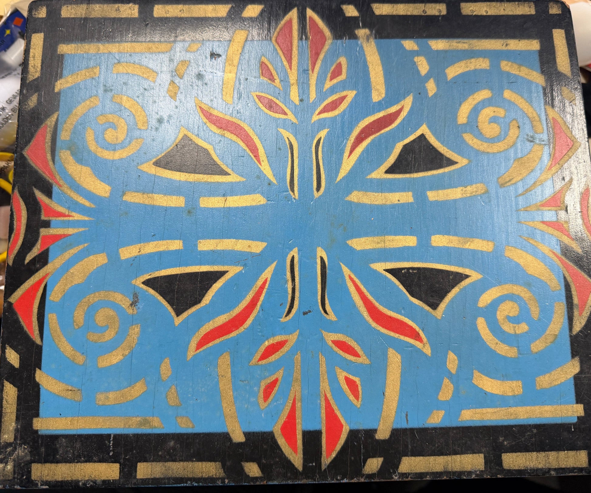 Decorative wooden panel with geometric pattern on a black background