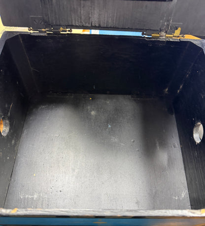 Empty black metal container with a lid on a concrete floor