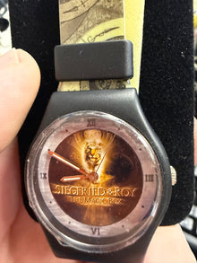 Watch with a unique design on the face, held by a person.