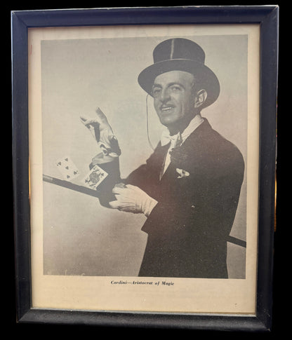 Framed vintage photograph of a man in formal attire with a top hat, holding playing cards.