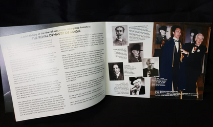 Open book with text and black and white photos on a dark background