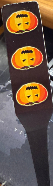 Keyboard with a Halloween-themed keychain on a cluttered desk