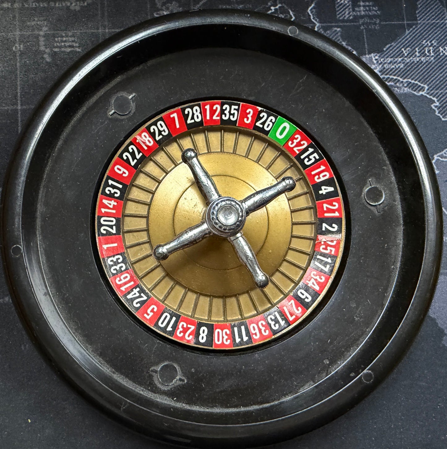 Close-up of a roulette wheel on a textured surface with map design