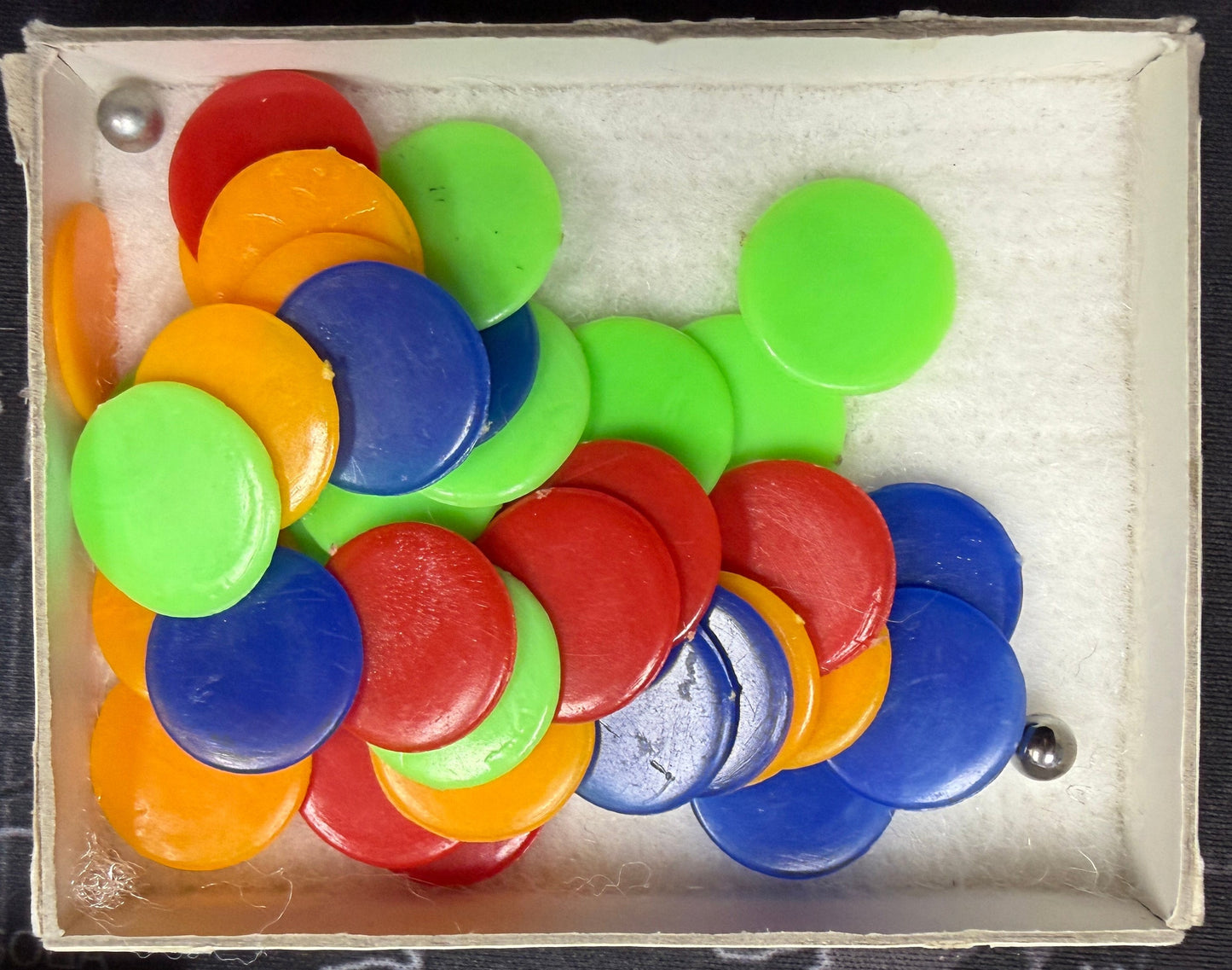 Box filled with colorful round buttons on a dark background