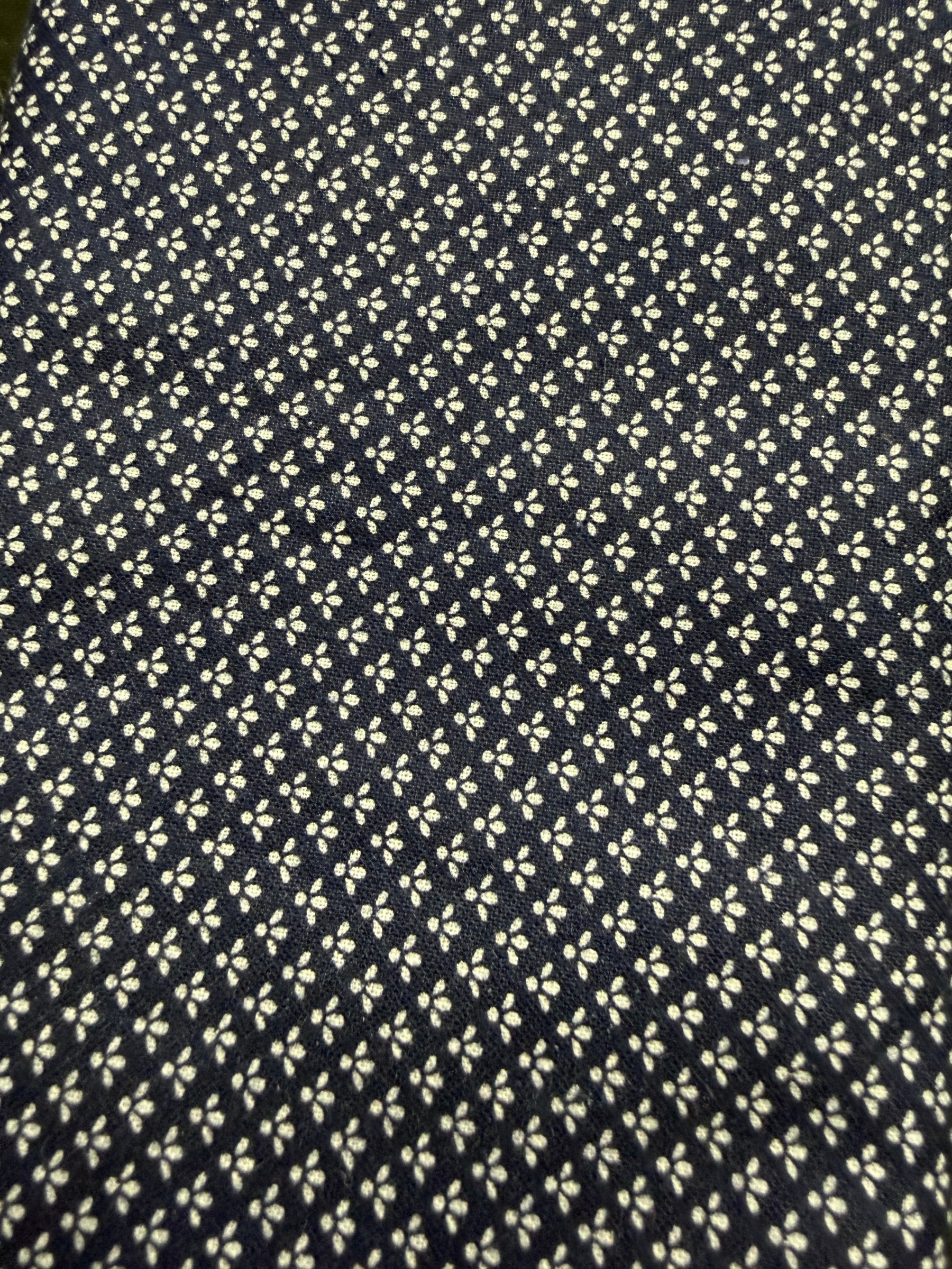 Navy blue fabric with small white floral pattern