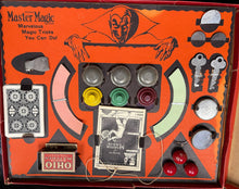 Vintage magic trick set with various components on an orange box labeled 'Ohio Master of Magic'.