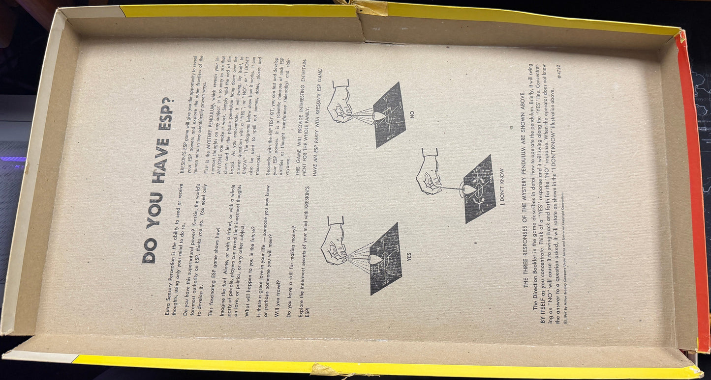 Open cardboard box with printed text and diagrams on a wooden surface.