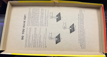 Open cardboard box with printed text and diagrams on a wooden surface.