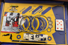 Vintage Gilbert Mysto Magic set with rings, cards, and other props on a yellow box.