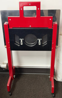Red car lift jack on a gray floor with a white wall background