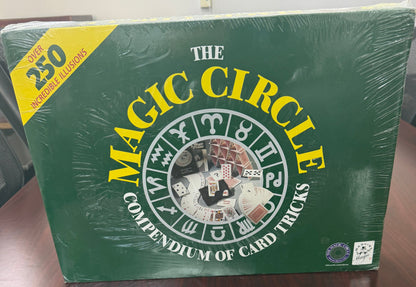 Green book titled 'The Magic Circle' on a wooden surface