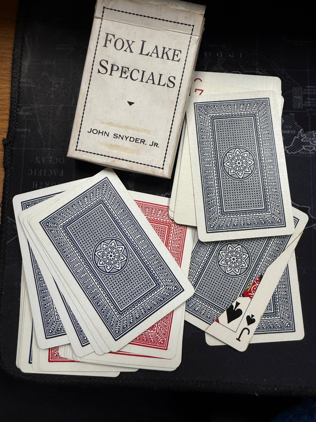 Playing cards with 'Fox Lake Specials' packaging on a dark surface