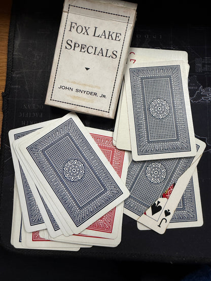 Playing cards with 'Fox Lake Specials' packaging on a dark surface