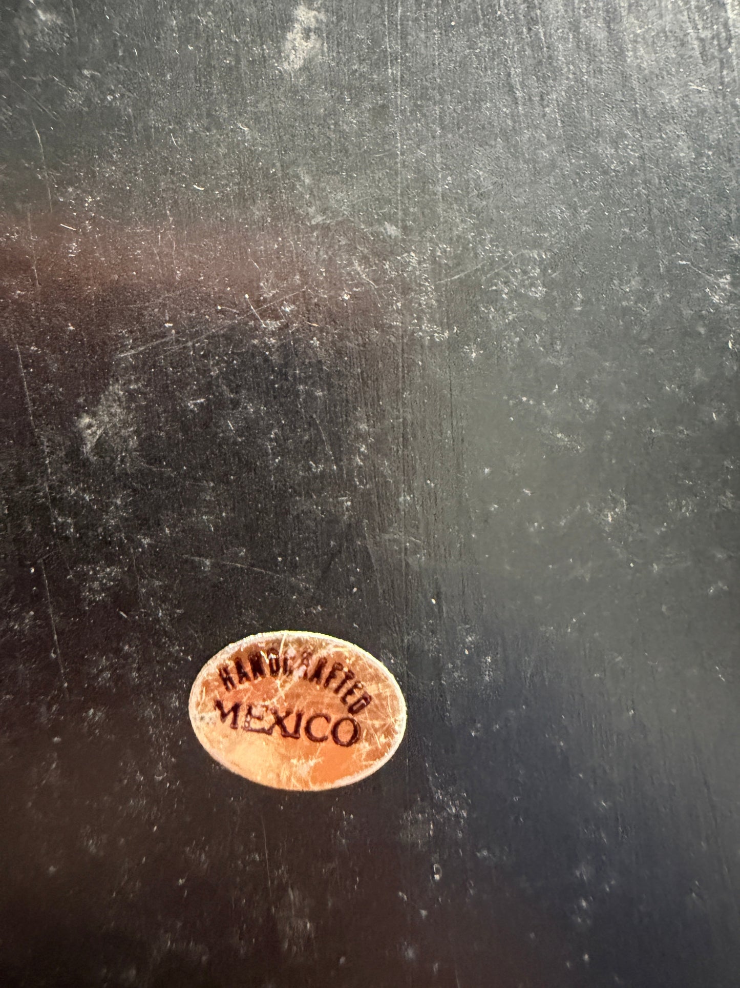 Small oval stamp on a dark textured surface