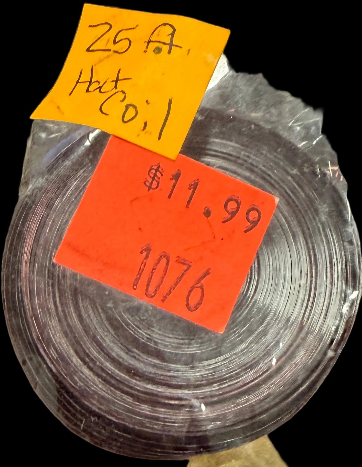 Roll of black tape in clear plastic packaging with price stickers on a map background