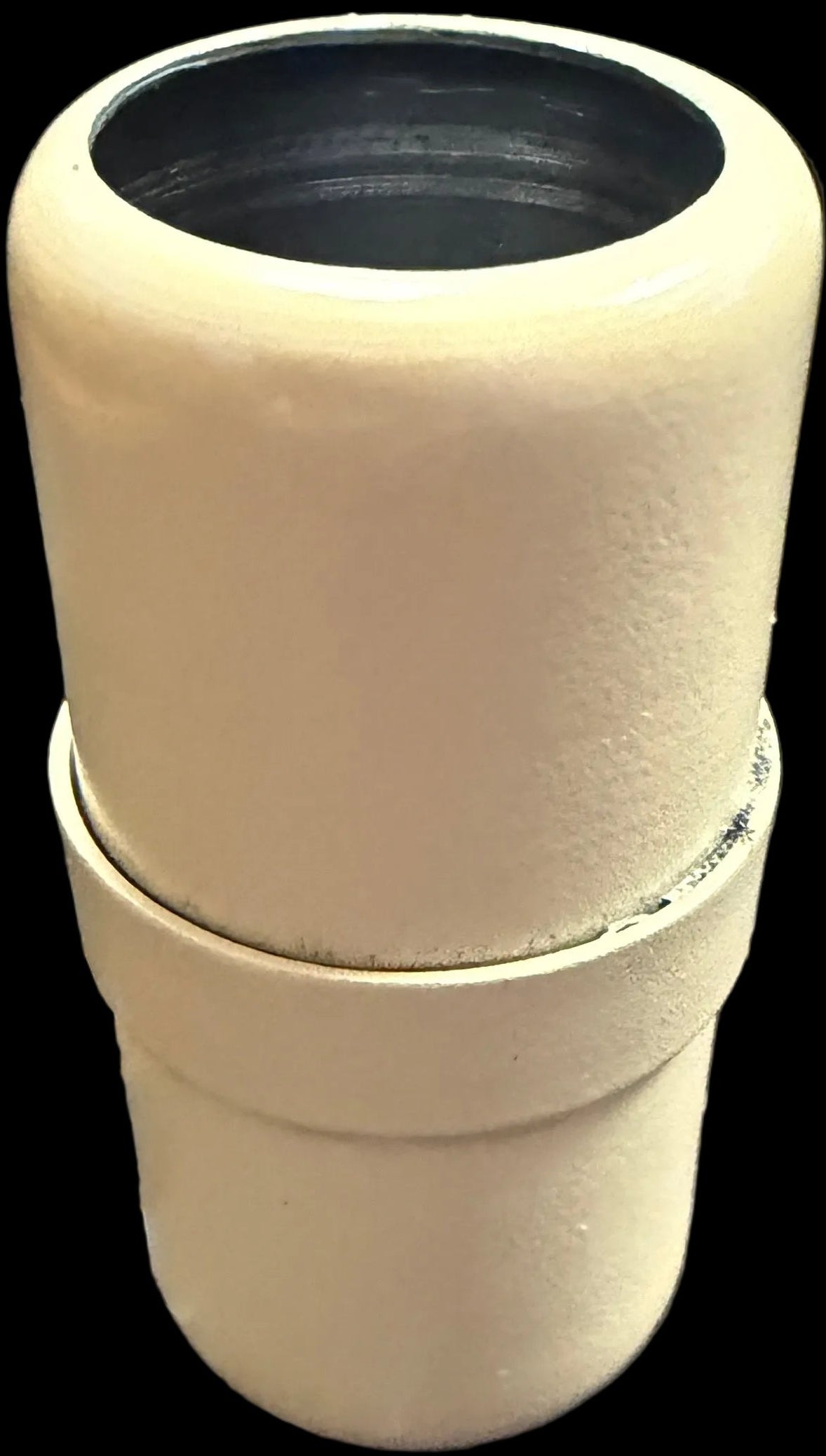 Stack of white ceramic pots with a black interior on a white background