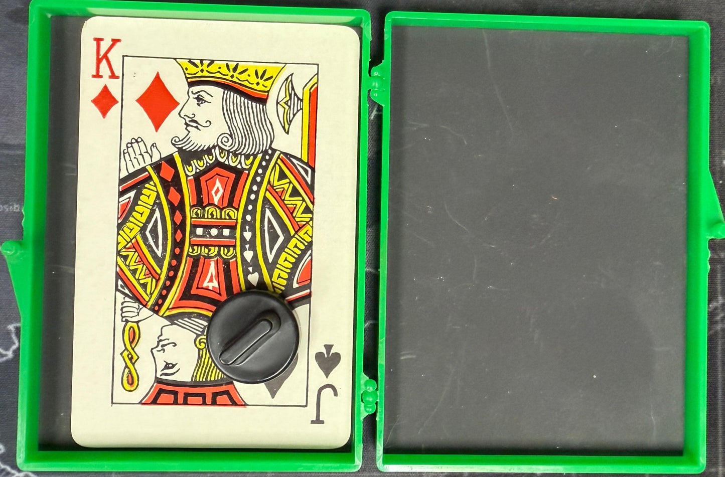 Playing card with a decorative design in a green holder on a map background
