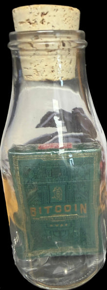 Bottle labeled 'Bitcoin' with a cork lid on a dark background