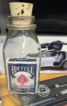 Bicycle brand bottle on a table with various items in the background