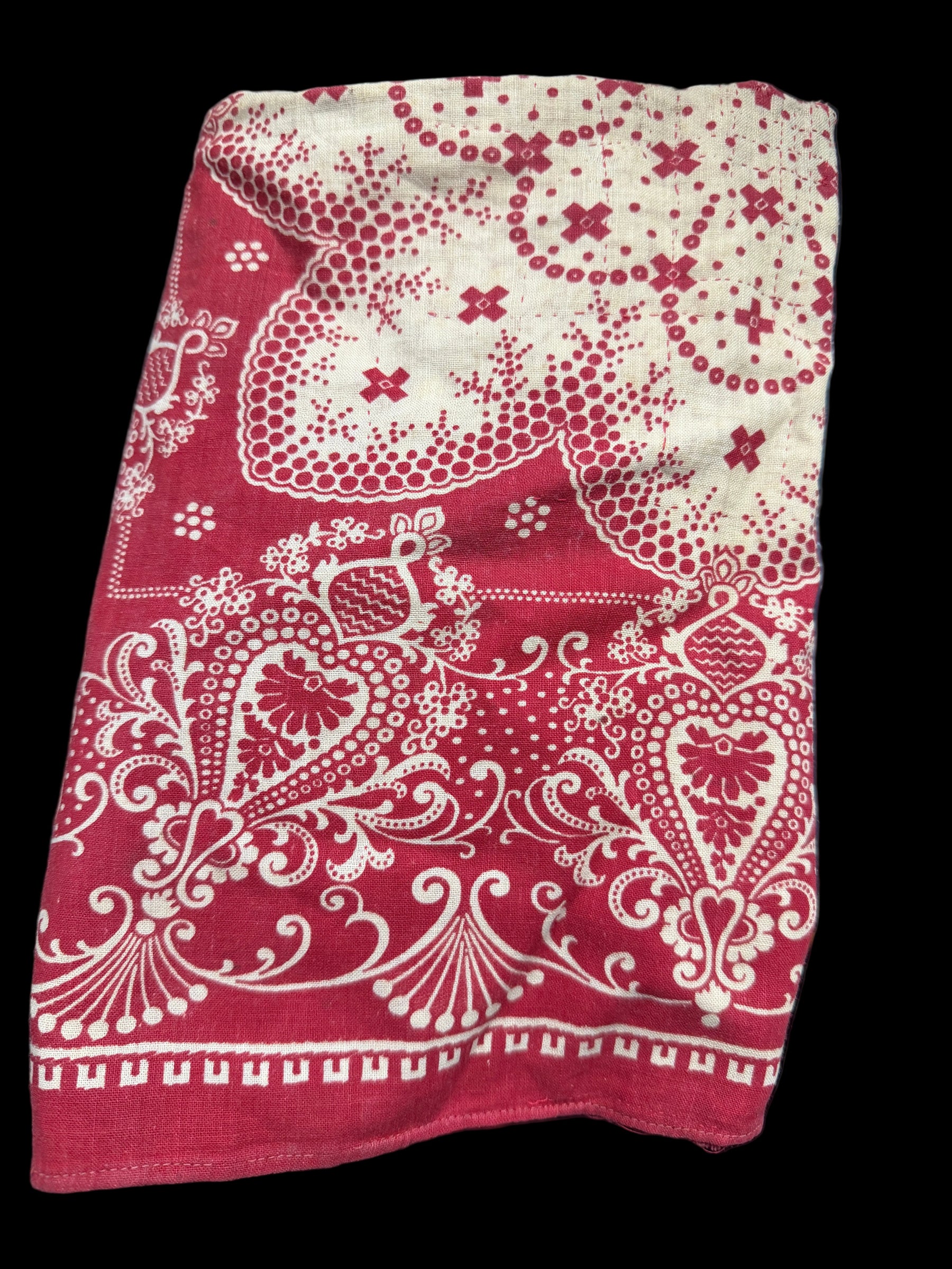 Red and white patterned fabric on a dark surface