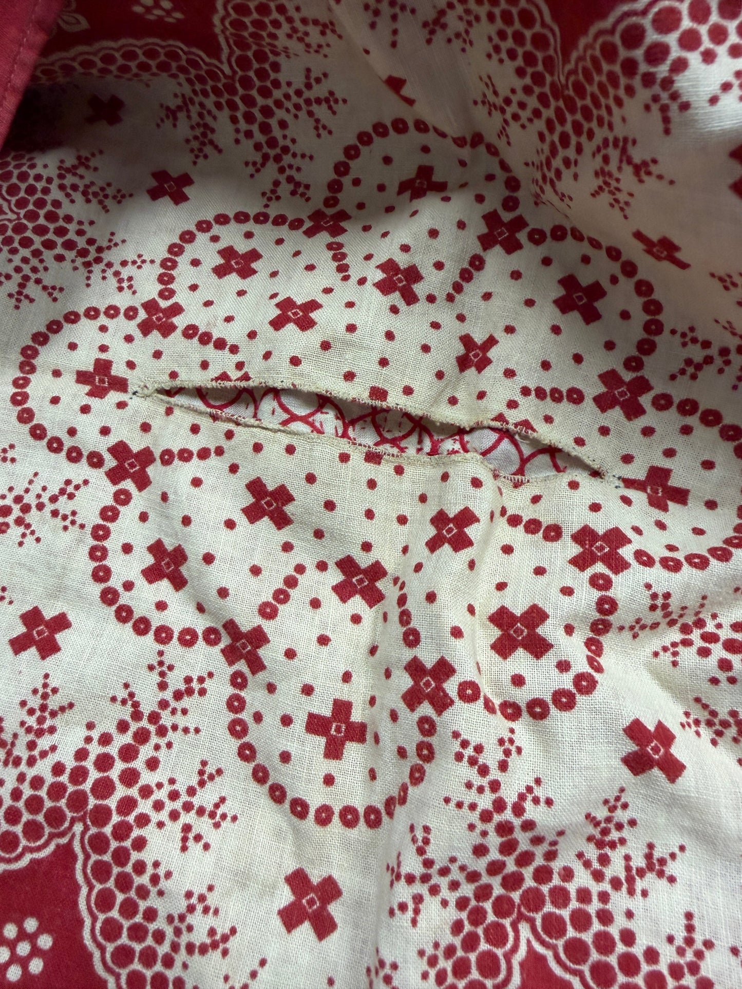 Close-up of fabric with red floral pattern on white background