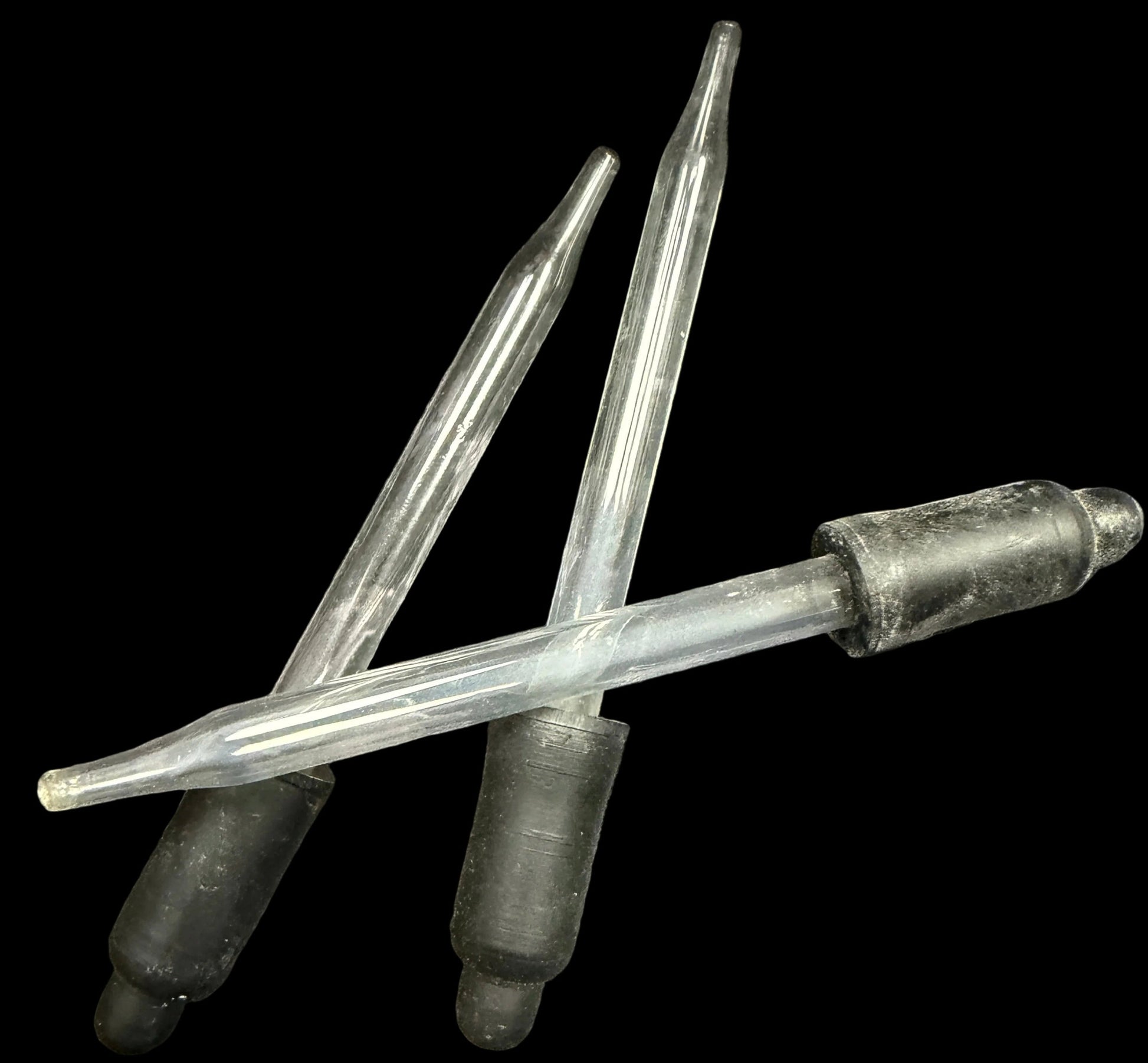 Two metal needles with black rubber tips on a white background