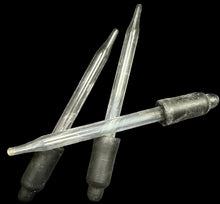 Two metal needles with black rubber tips on a white background