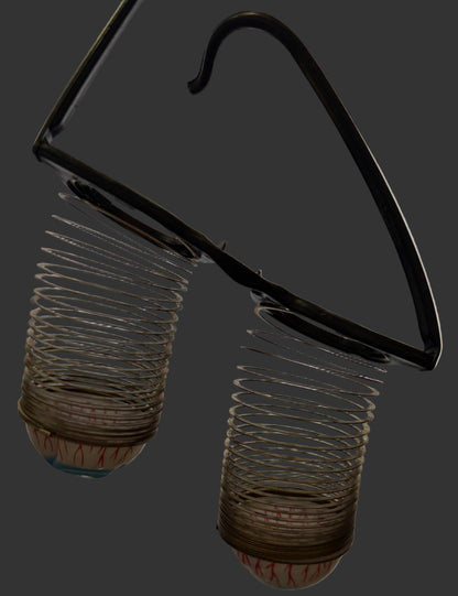 Two metal springs on a white surface with a computer screen in the background