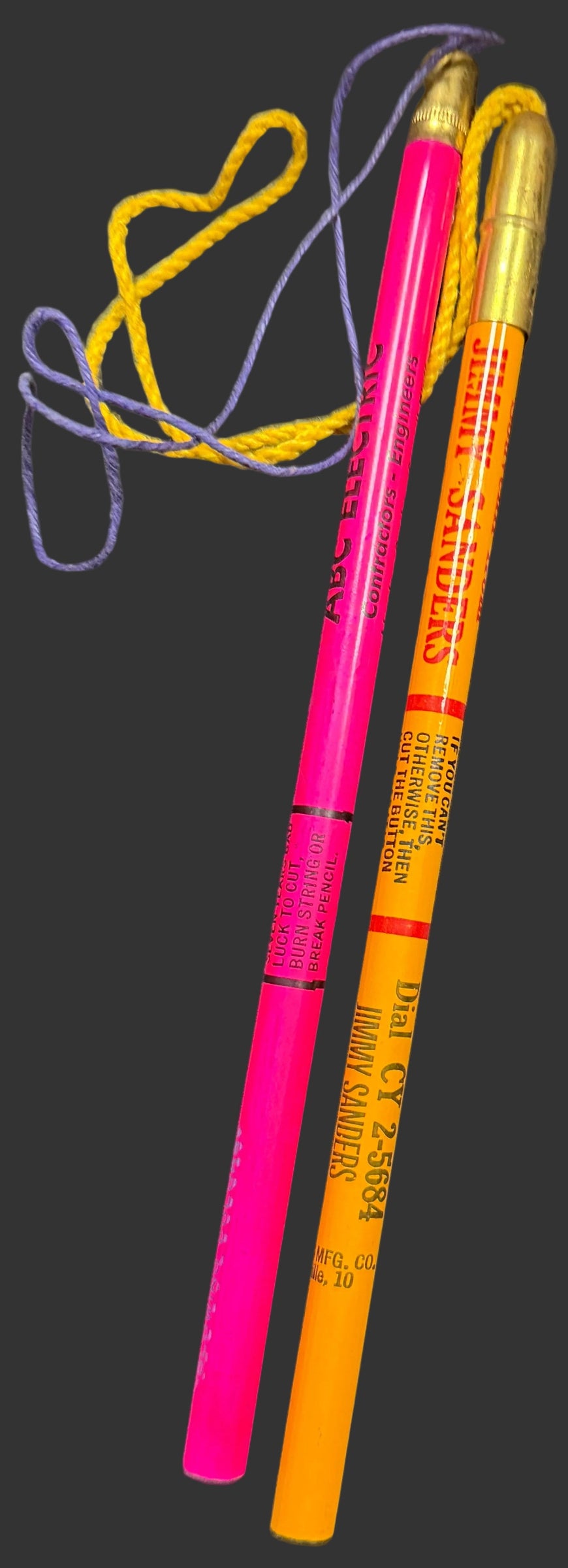 Two highlighters, one pink and one orange, on a black background.