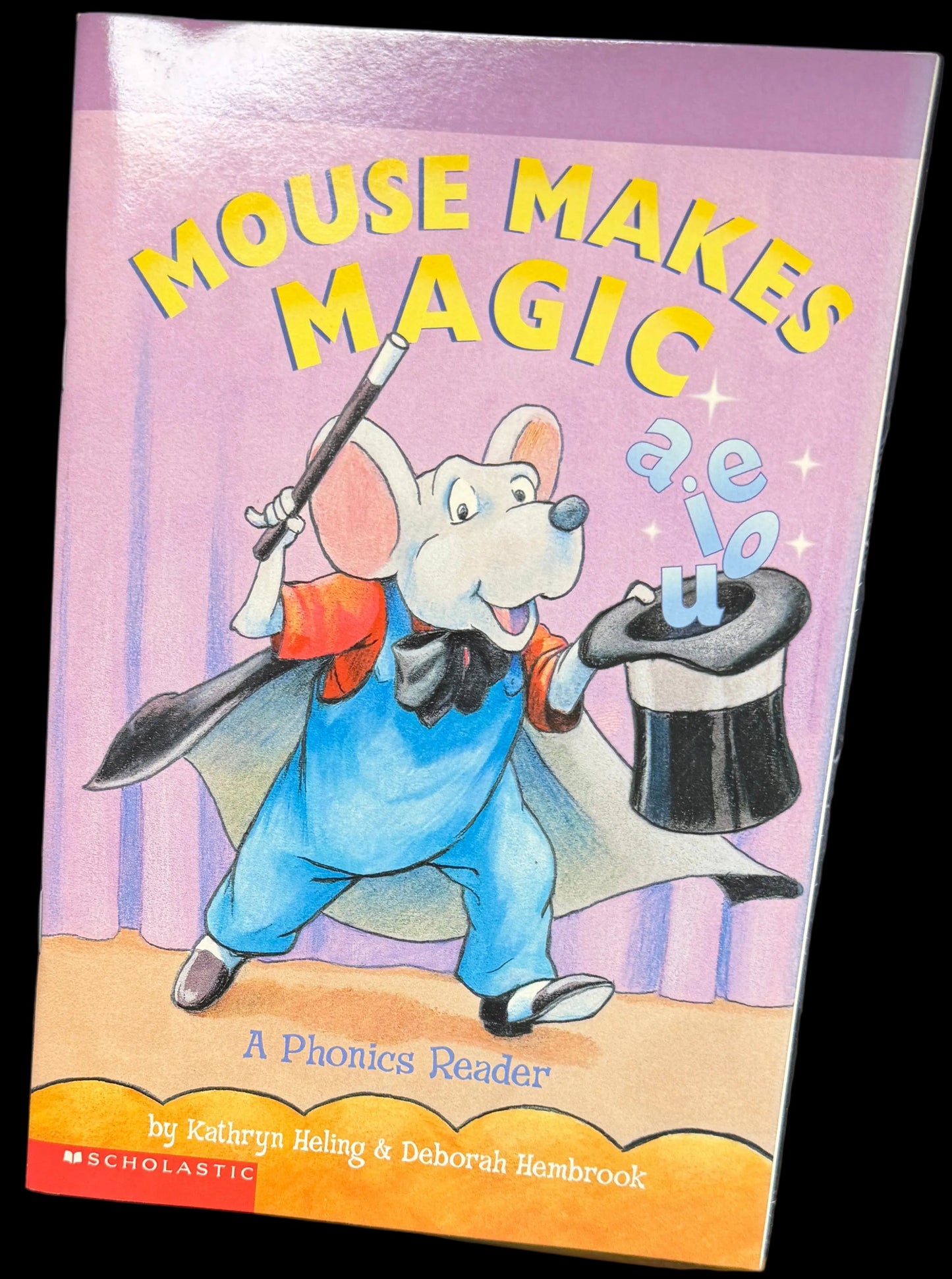 Children's book titled 'Mouse Makes Magic' on a surface with a map in the background.