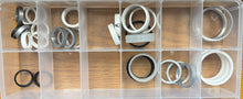 Clear plastic organizer with various metal washers on a wooden surface