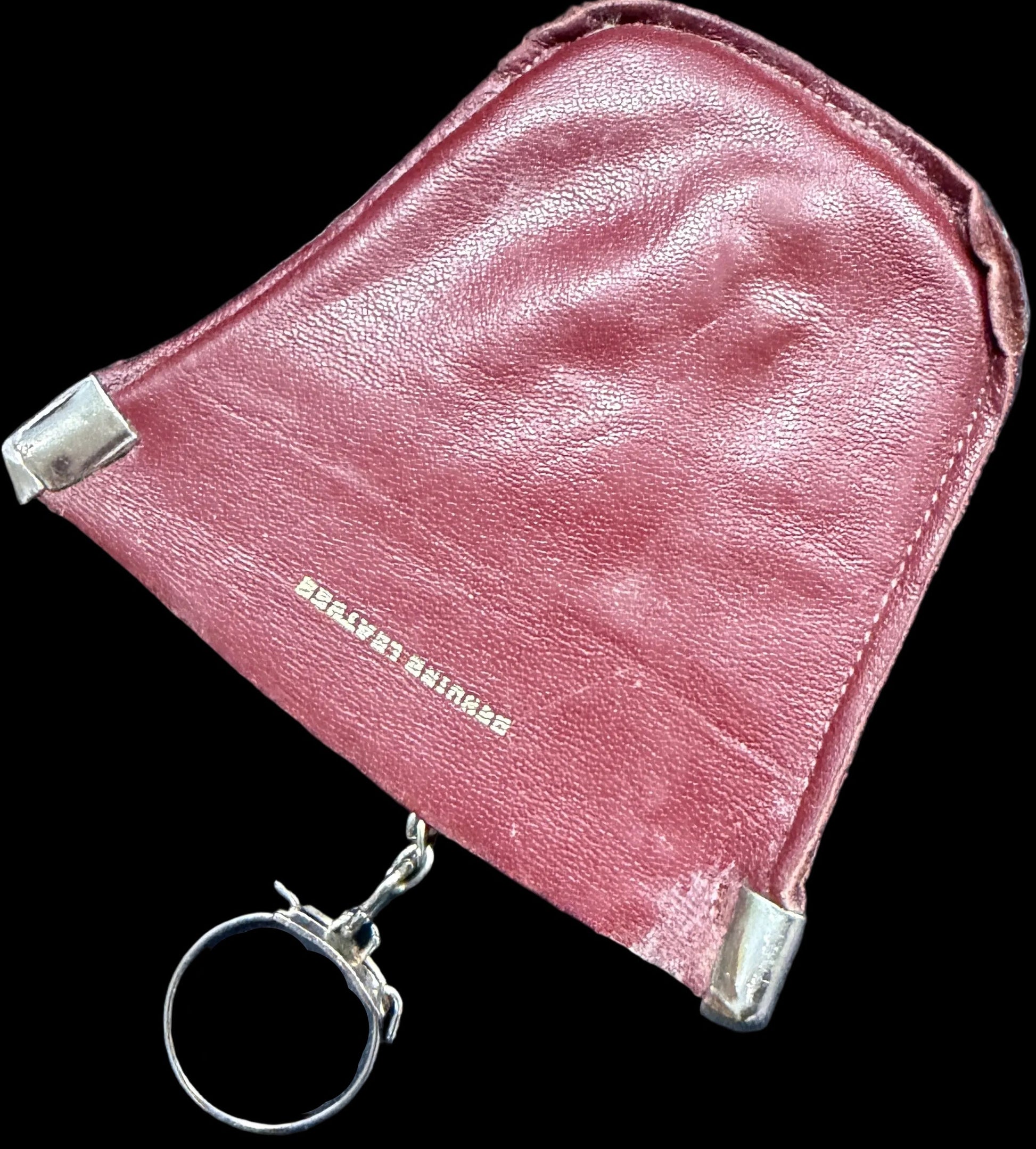 Pink leather pouch with keychain on a world map background