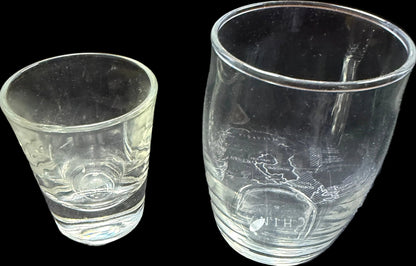 Two etched glass tumblers on a map of Russia