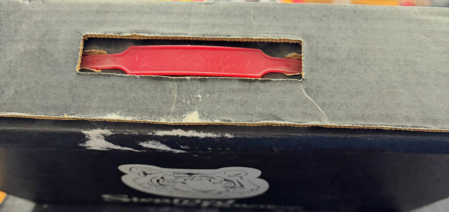 Close-up of a book with a red tool-like object inside, on a blurred background.