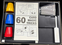 Card magic tricks set with cups and a knife on a table
