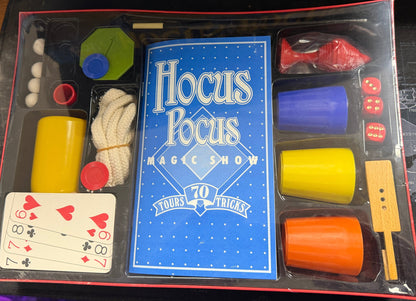 Hocus Pocus magic show kit with cards and cups on a table.