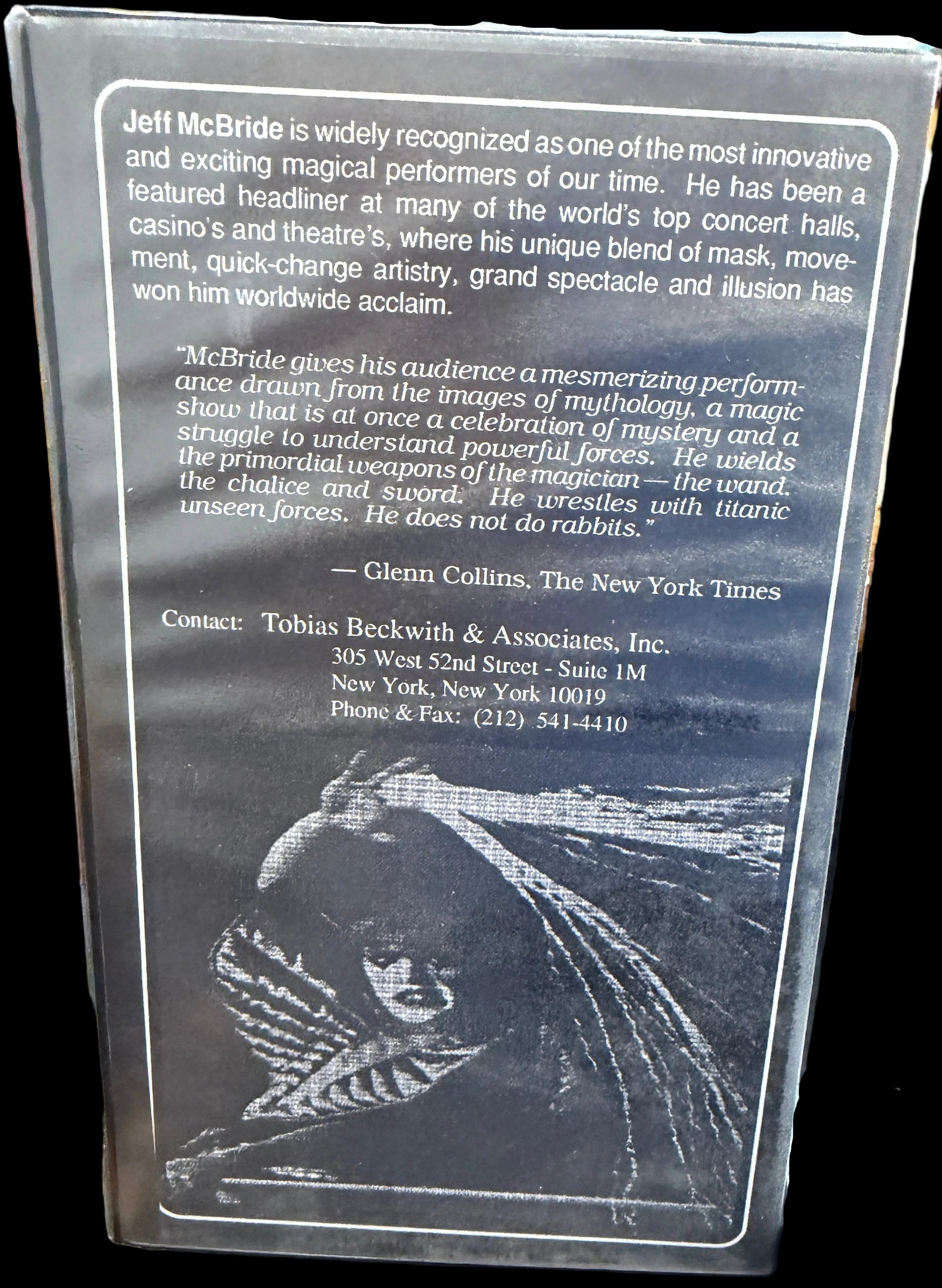 Metallic card with engraved text and image on a wooden surface