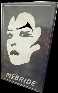 Sticker with a logo and 'McBride' text on a dark surface